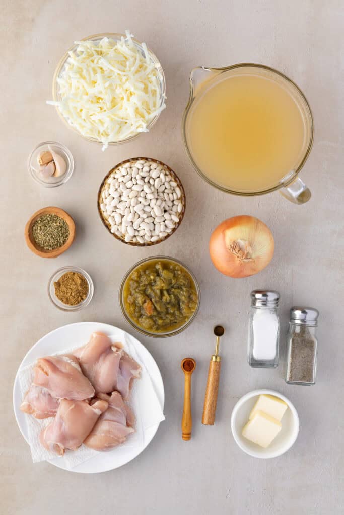 Ingredients for white bean and chicken chili. Onions, chicken stock, salt, pepper, butter, cloves, cayenne, oregano, chicken, green chiles, garlic, white beans, Monterey Jack cheese.